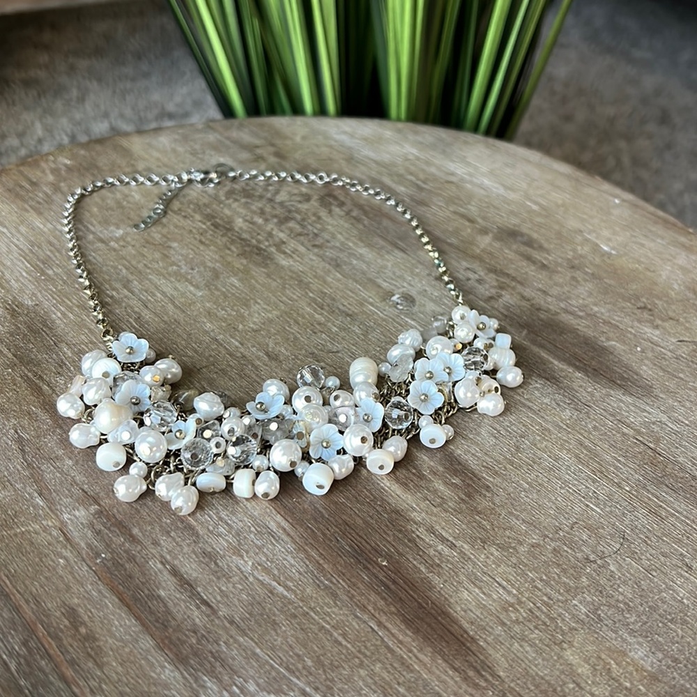 White/cream statement necklace with chain,beads,and flowers.